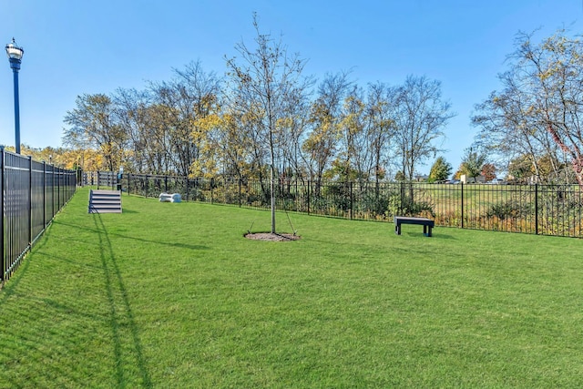 view of community featuring a yard and fence