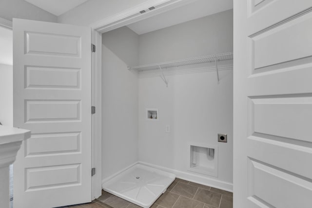 laundry area featuring electric dryer hookup, dark tile patterned flooring, baseboards, hookup for a washing machine, and laundry area