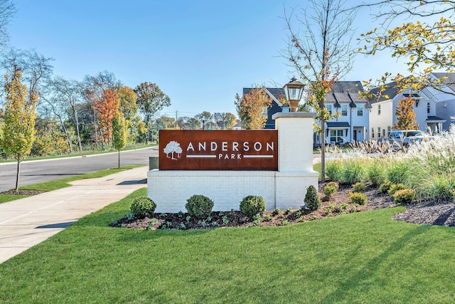 community / neighborhood sign with a residential view and a lawn