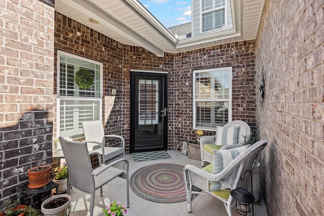 view of exterior entry featuring brick siding