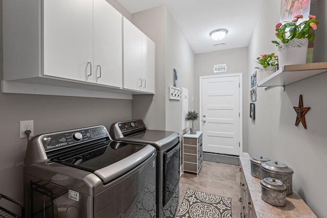 washroom featuring washer and dryer, visible vents, and cabinet space