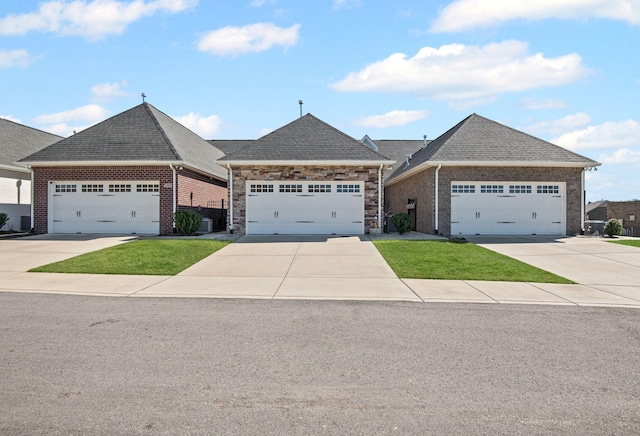 view of front of house with brick siding, concrete driveway, roof with shingles, and a front yard