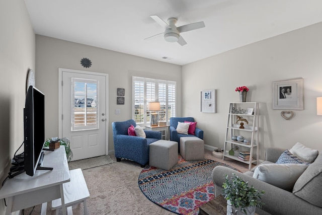 living room with visible vents, ceiling fan, and carpet flooring