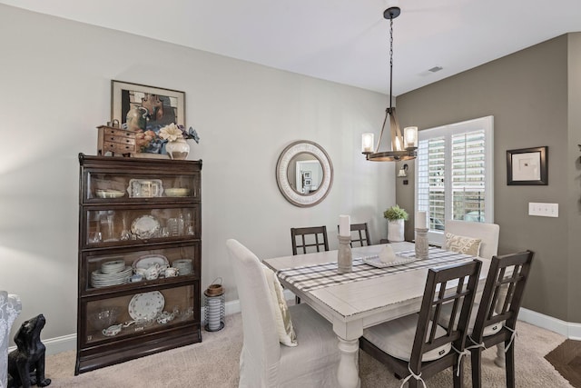 dining room with an inviting chandelier, light colored carpet, baseboards, and visible vents