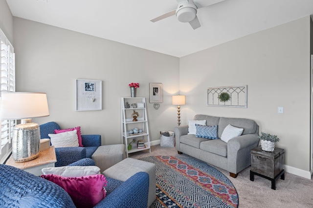 carpeted living room featuring baseboards and ceiling fan