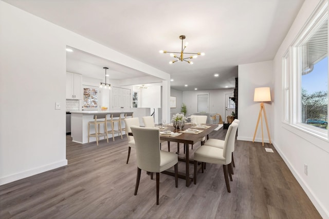 dining room featuring recessed lighting, baseboards, an inviting chandelier, and wood finished floors