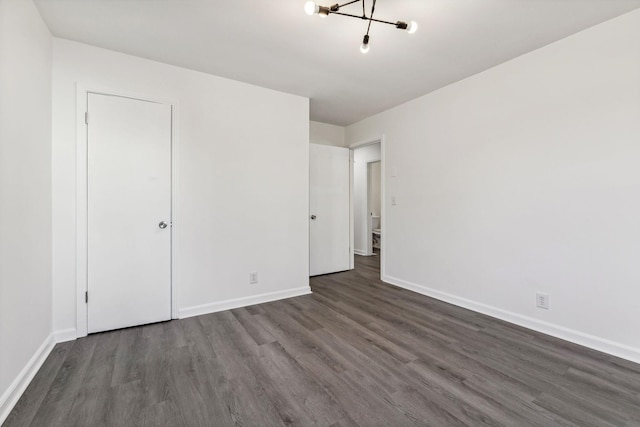 unfurnished bedroom with dark wood-type flooring and baseboards