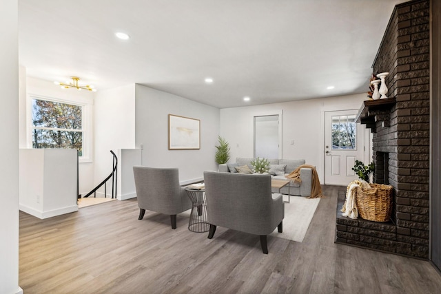 dining room featuring a brick fireplace, recessed lighting, and wood finished floors