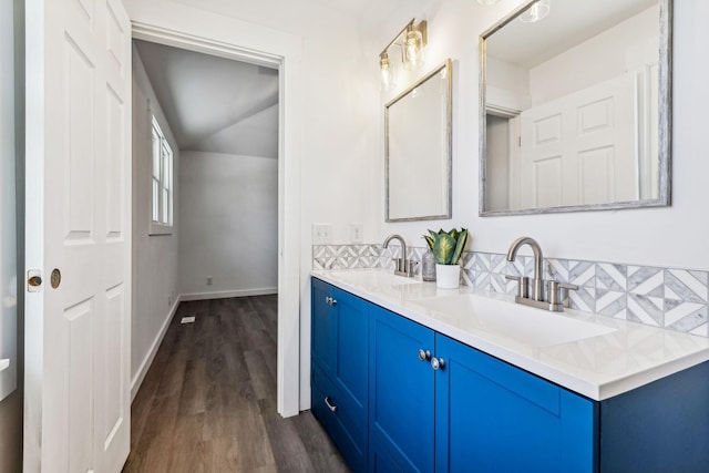 full bathroom with a sink, tasteful backsplash, wood finished floors, and double vanity