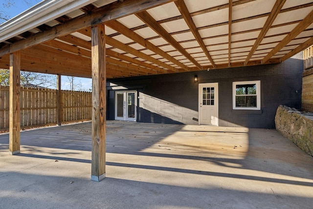 view of patio with an attached carport and fence