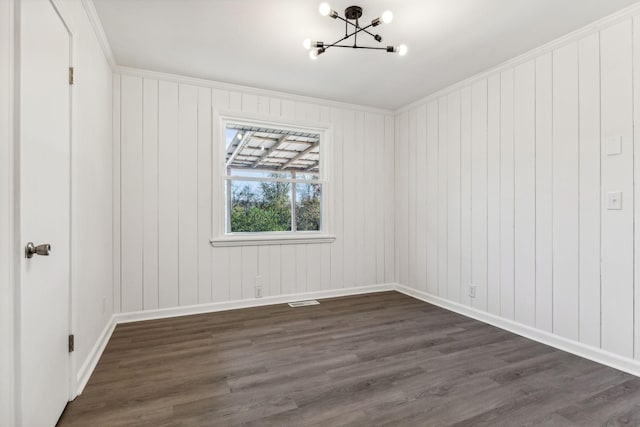 spare room featuring visible vents, crown molding, dark wood-type flooring, baseboards, and a chandelier