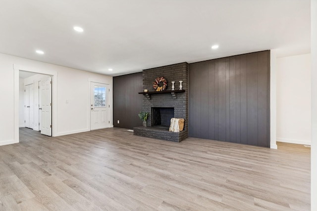 unfurnished living room featuring a fireplace, recessed lighting, wood finished floors, and baseboards