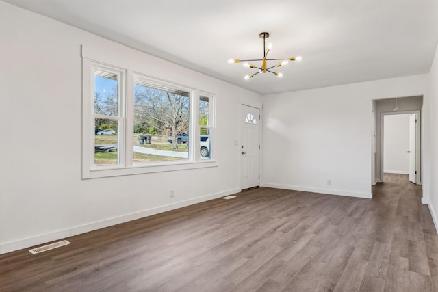 entryway featuring visible vents, baseboards, a notable chandelier, and wood finished floors