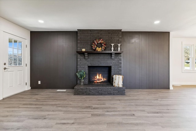 unfurnished living room with wood finished floors, recessed lighting, and a fireplace