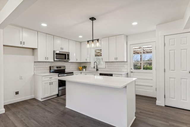 kitchen featuring backsplash, light countertops, white cabinets, stainless steel appliances, and dark wood-style flooring