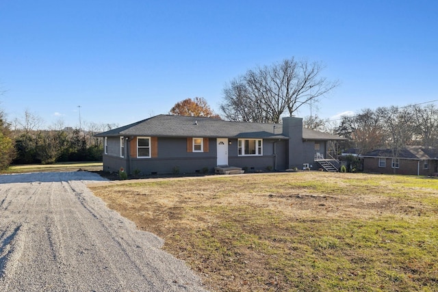 ranch-style home featuring crawl space, driveway, brick siding, and a front lawn