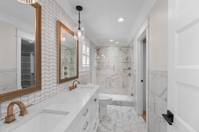 full bathroom with tile walls, toilet, a marble finish shower, and a sink