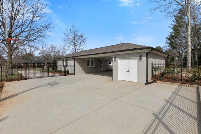 rear view of property with concrete driveway, fence, brick siding, and a carport