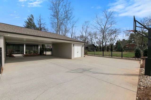 exterior space featuring fence, a garage, driveway, and a shingled roof