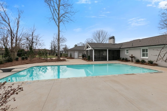 view of pool featuring a patio area, a fenced in pool, and a sunroom