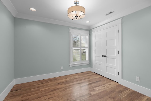 empty room with recessed lighting, visible vents, baseboards, and wood finished floors