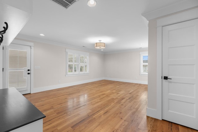 living room with crown molding, visible vents, and a wealth of natural light