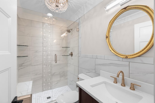 bathroom with vanity, toilet, a stall shower, tile walls, and a notable chandelier