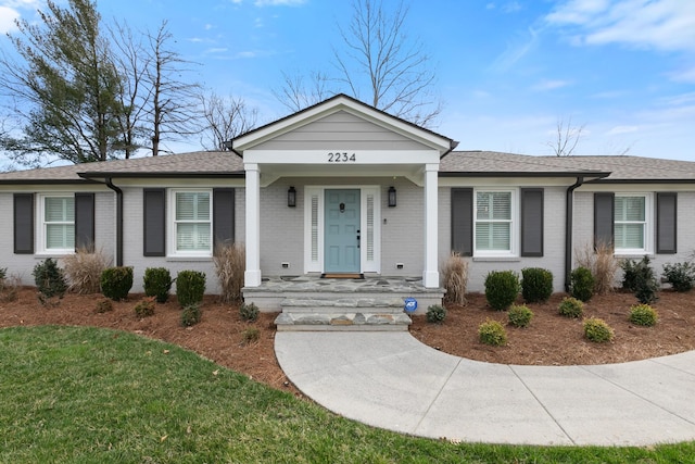 single story home with a front lawn, brick siding, and a shingled roof