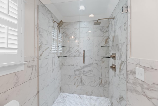 bathroom with tile walls, recessed lighting, and a stall shower