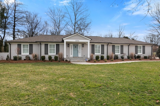 single story home with brick siding, a front yard, and a shingled roof