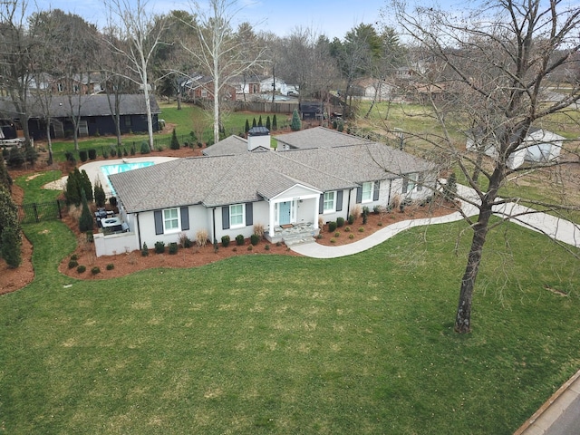 single story home with a shingled roof, a front yard, and fence