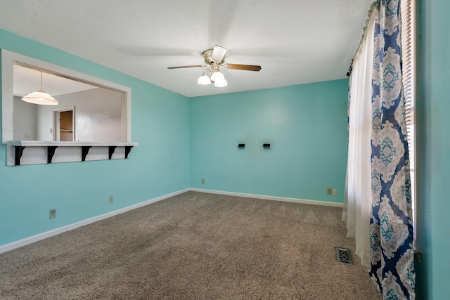 unfurnished room featuring baseboards, carpet, ceiling fan, and a textured ceiling