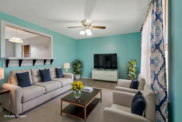 carpeted living area with ceiling fan