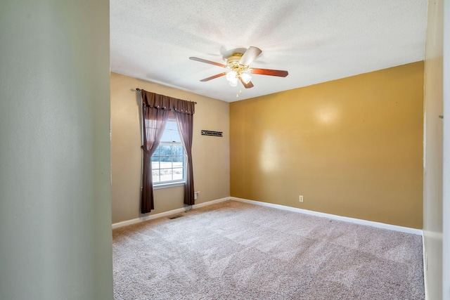 empty room featuring visible vents, baseboards, ceiling fan, carpet flooring, and a textured ceiling