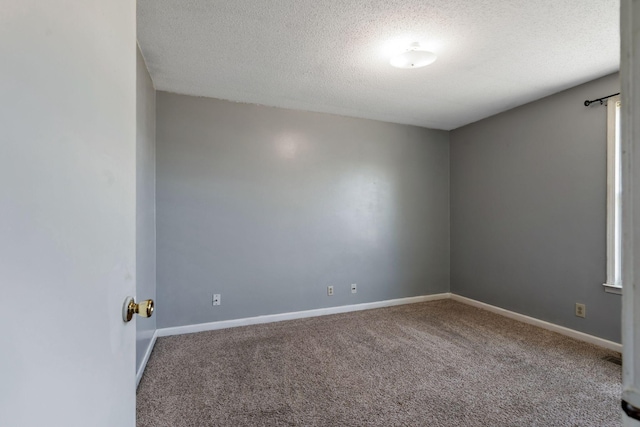 unfurnished room featuring carpet flooring, a textured ceiling, and baseboards