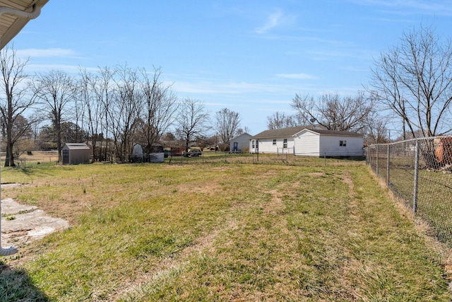 view of yard featuring an outbuilding, a storage unit, and fence