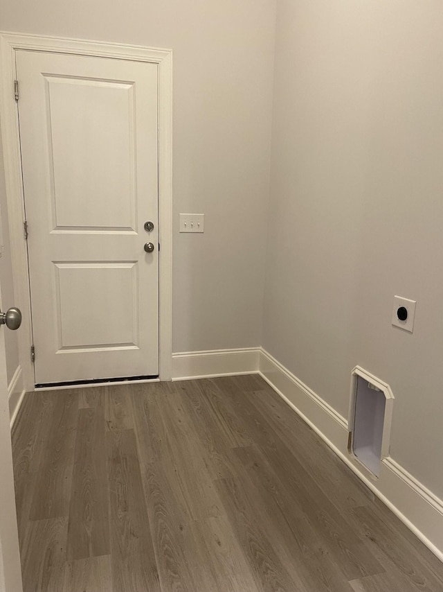 clothes washing area with baseboards, hookup for an electric dryer, dark wood-style flooring, and laundry area