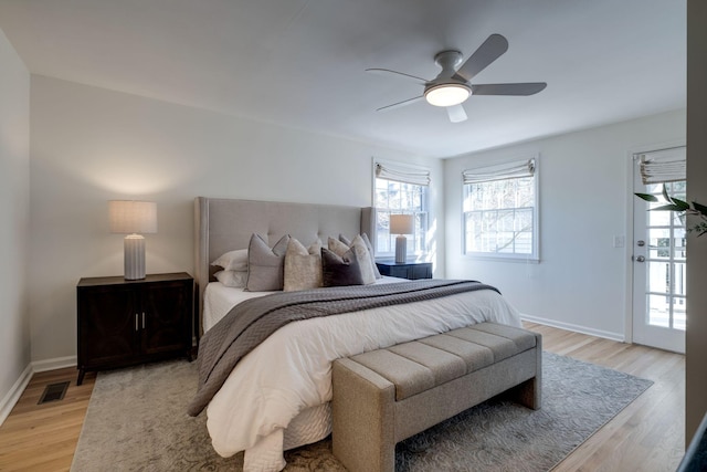 bedroom with light wood-style flooring, baseboards, visible vents, and ceiling fan