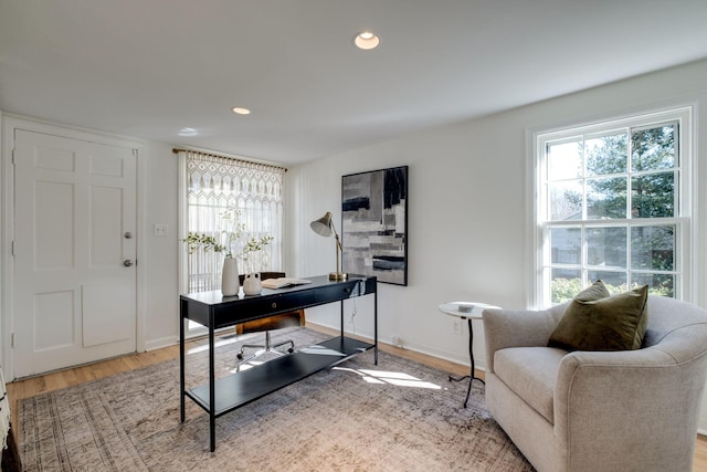 office space with recessed lighting, baseboards, light wood-style floors, and a fireplace