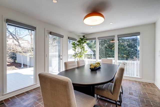 dining area with recessed lighting, baseboards, and brick floor