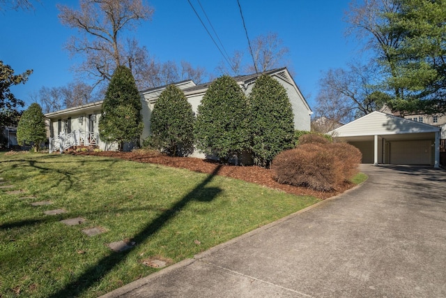 view of side of property with a detached garage, a lawn, and an outdoor structure