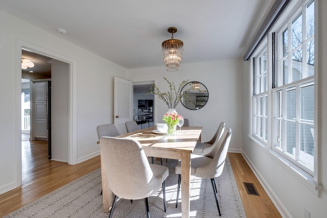 dining area with a healthy amount of sunlight, visible vents, and light wood finished floors