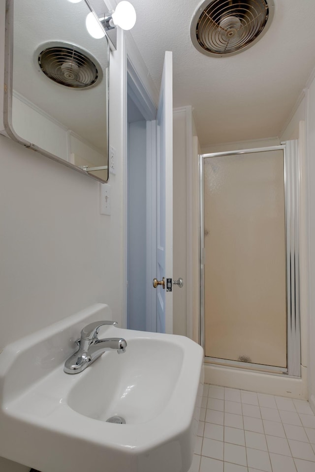 full bath with a sink, tile patterned floors, visible vents, and a stall shower