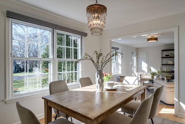 dining room with light wood finished floors and a chandelier