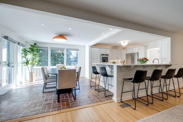 dining room featuring recessed lighting, baseboards, and light wood finished floors