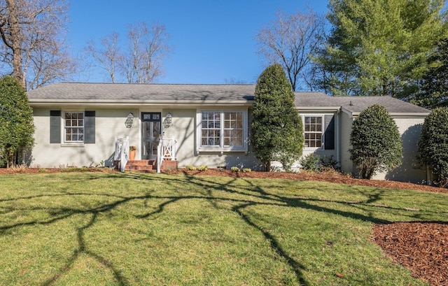 ranch-style house featuring a front lawn and brick siding