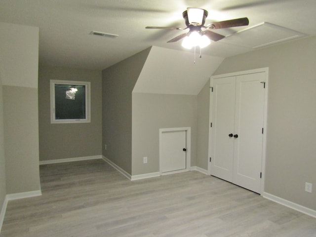 additional living space with a ceiling fan, light wood-style flooring, baseboards, and visible vents