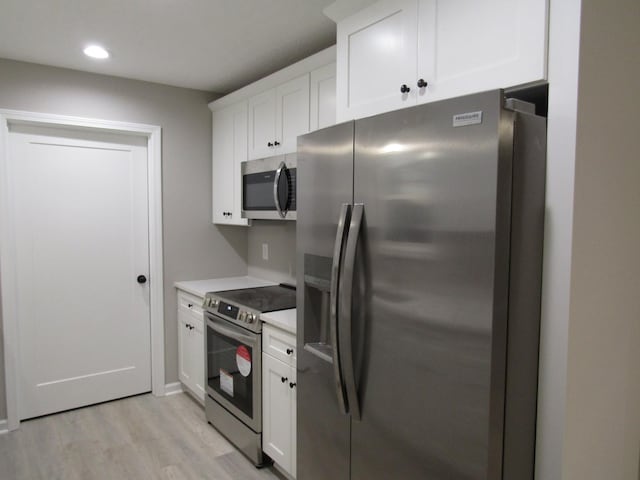 kitchen featuring recessed lighting, stainless steel appliances, white cabinets, light wood finished floors, and light countertops