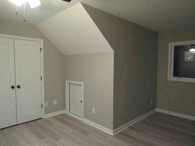 bonus room with vaulted ceiling, wood finished floors, baseboards, and ceiling fan