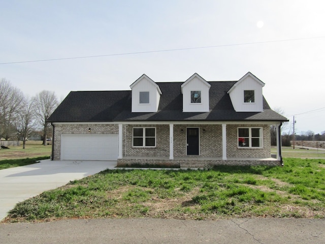 cape cod-style house with brick siding, covered porch, an attached garage, and concrete driveway